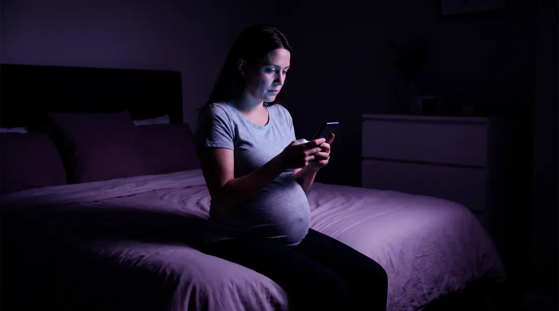 Grávida acordada de madrugada com o celular na mão